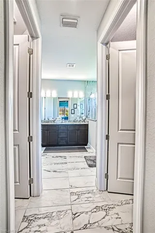 Corridor featuring a textured ceiling and light tile floors