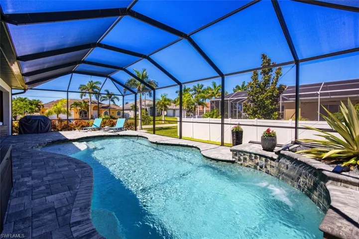 View of swimming pool with pool water feature and glass enclosure