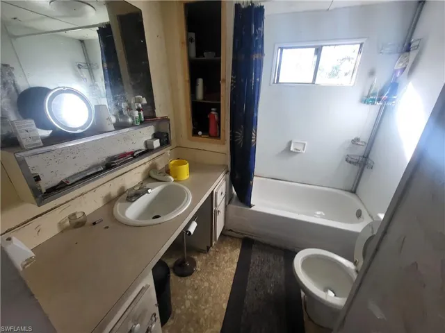 Full bathroom featuring toilet, vanity, and shower / bath combo with shower curtain