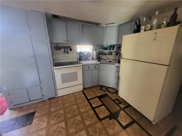 Kitchen featuring decorative backsplash, sink, and white appliances
