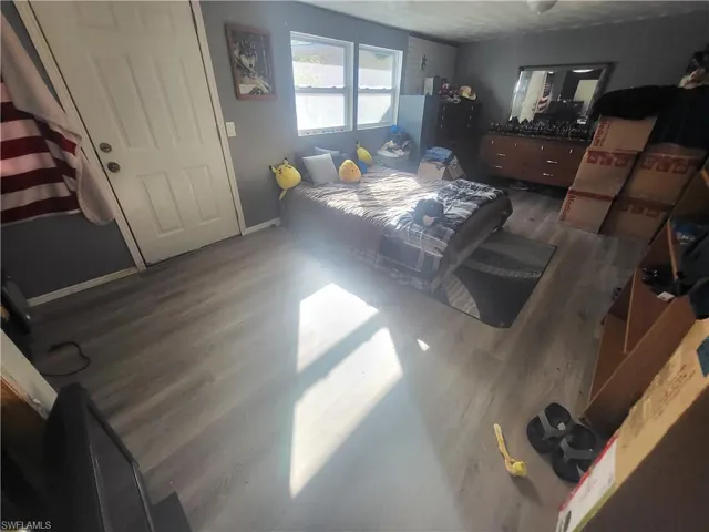 Bedroom with dark wood-type flooring and a textured ceiling