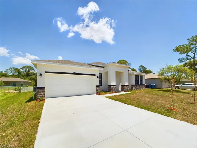 View of front of house featuring a garage and a front lawn