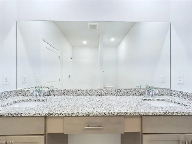 Bathroom featuring toilet, walk in shower, and vanity