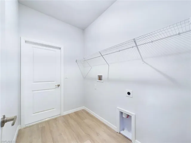 Laundry area featuring light hardwood / wood-style floors, hookup for a washing machine, and electric dryer hookup