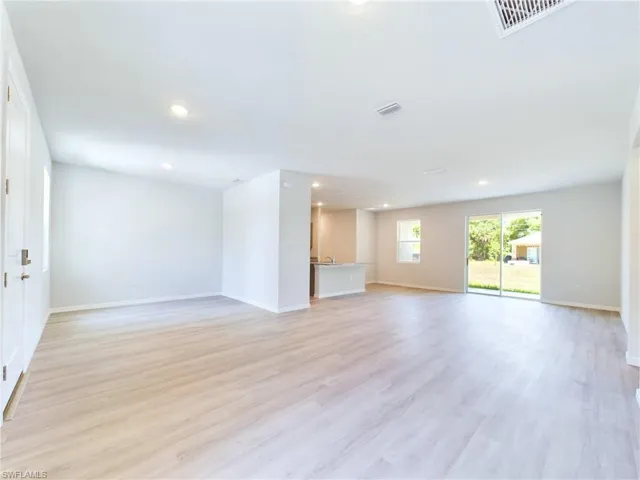 Unfurnished living room with sink and light hardwood / wood-style flooring
