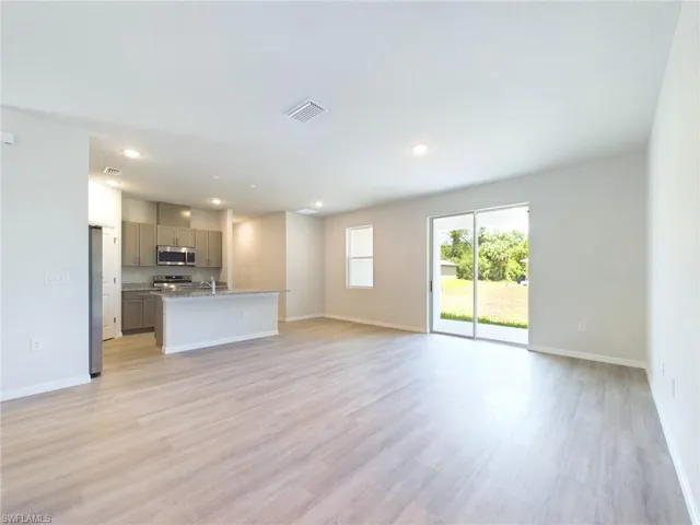 Unfurnished living room featuring light hardwood / wood-style floors and sink