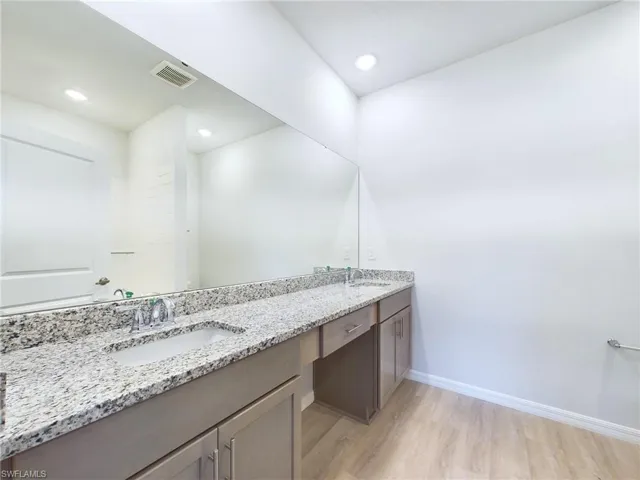 Bathroom with hardwood / wood-style flooring and vanity