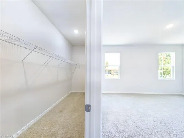 Walk in closet featuring light carpet