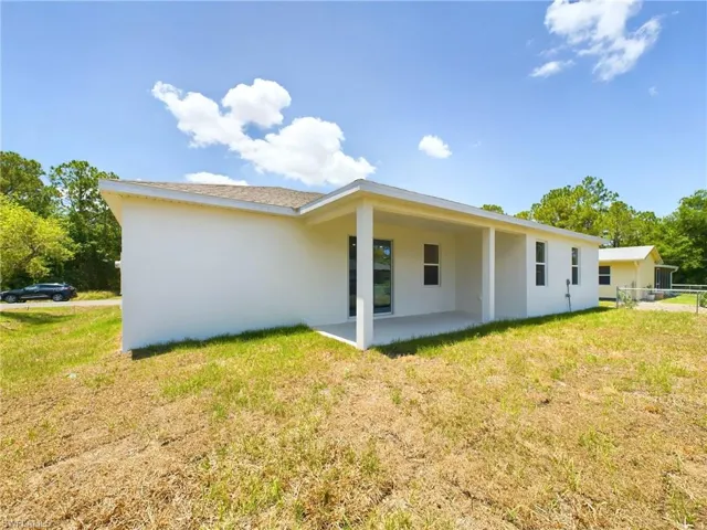 Rear view of house featuring a lawn and a patio area