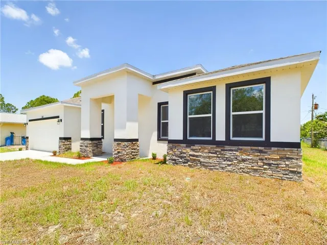 View of front of property featuring a garage and a front yard