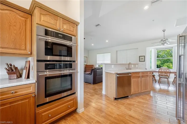 Kitchen featuring tasteful backsplash, light wood-type flooring, appliances with stainless steel finishes, ceiling fan, and sink
