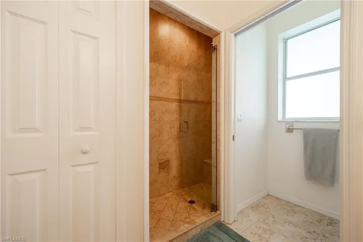 Bathroom with tile patterned floors and a shower with door