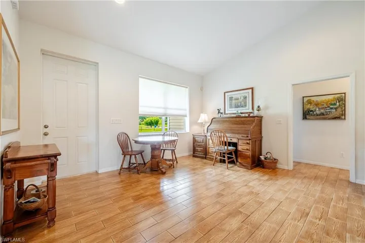 Living area with high vaulted ceiling and light hardwood / wood-style floors