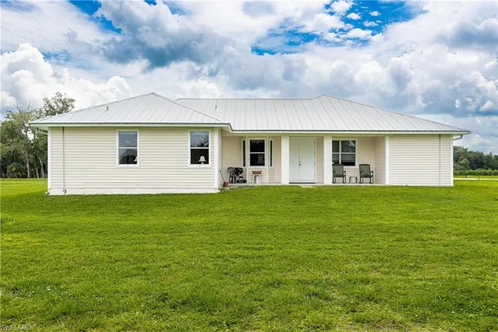 View of front of property with a porch and a front yard