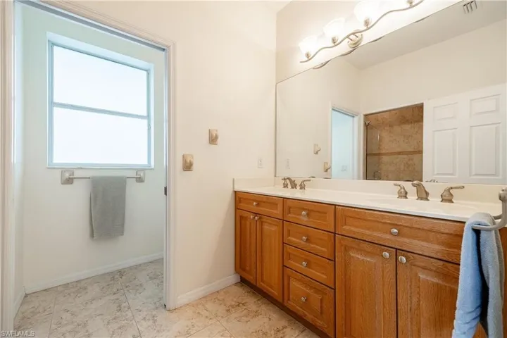 Bathroom with dual bowl vanity and tile patterned floors