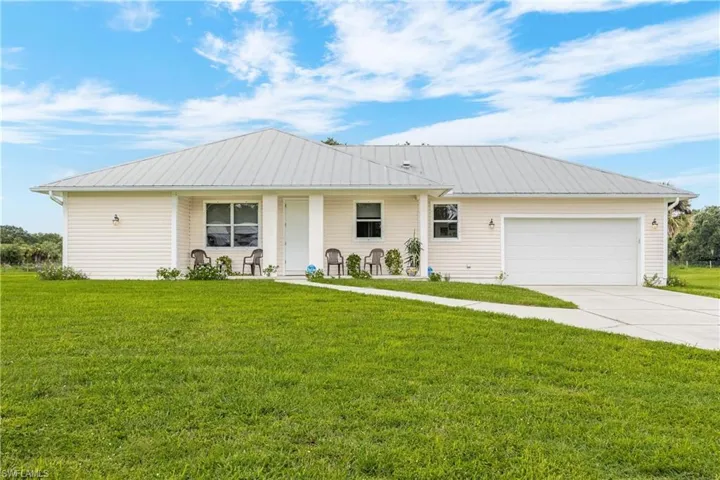 Ranch-style home featuring a front yard and a garage