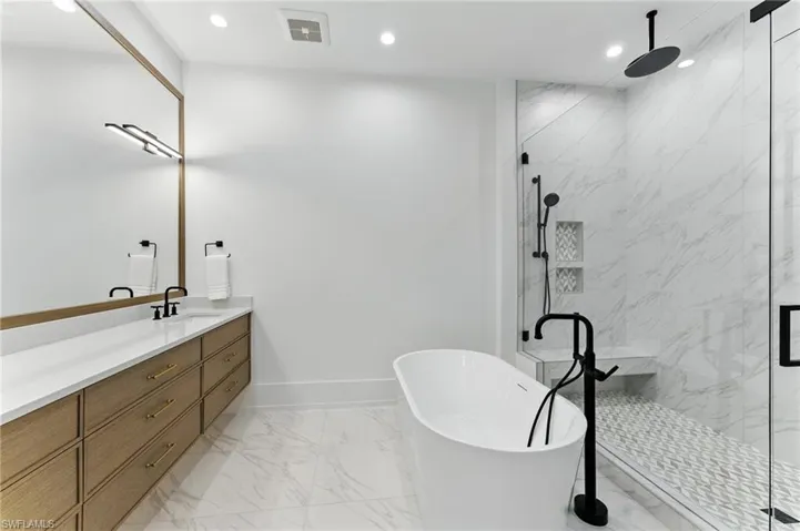 Bathroom with marble finish flooring, a soaking tub, vanity, a marble finish shower, and recessed lighting