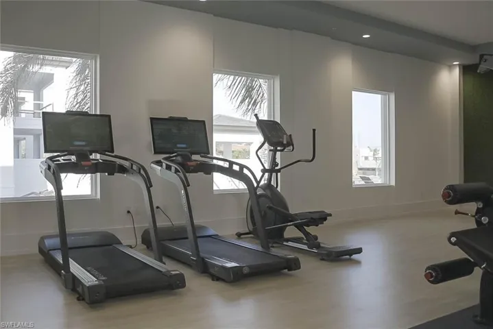Workout area featuring wood finished floors, plenty of natural light, and recessed lighting