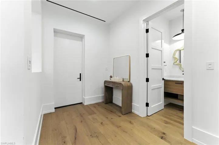 Corridor with light wood finished floors and baseboards