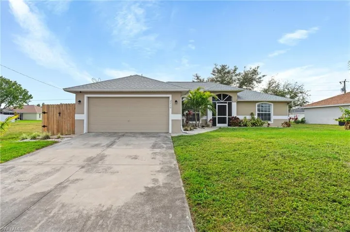 Ranch-style house featuring a garage and a front yard