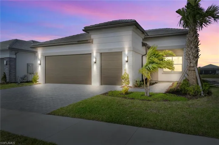 View of front of home with a garage and a lawn