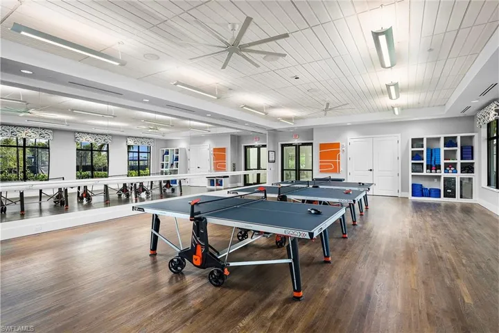 Recreation room featuring ceiling fan, dark hardwood / wood-style floors, and plenty of natural light