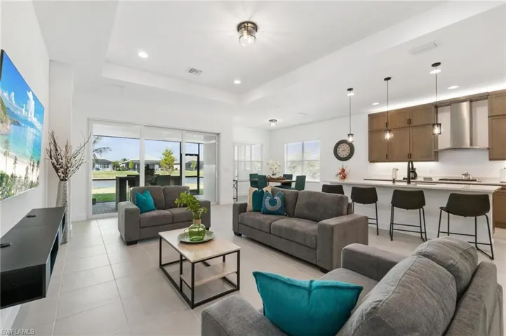 Tiled living room with sink and a tray ceiling