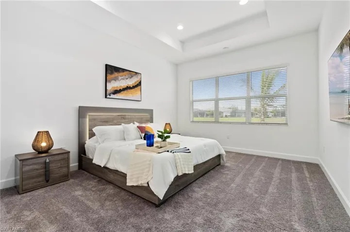 Bedroom featuring carpet floors and a raised ceiling