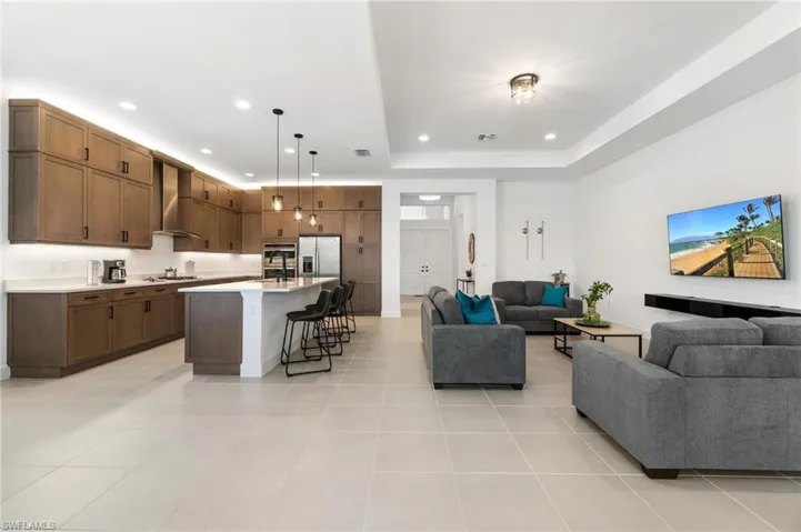 Tiled living room featuring sink and a tray ceiling