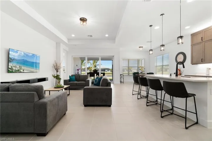 Tiled living room featuring a tray ceiling