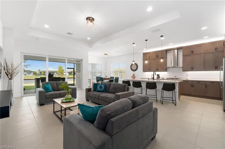 Living room featuring a raised ceiling and light tile patterned floors