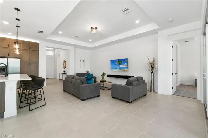 Living room featuring light tile patterned floors and a raised ceiling
