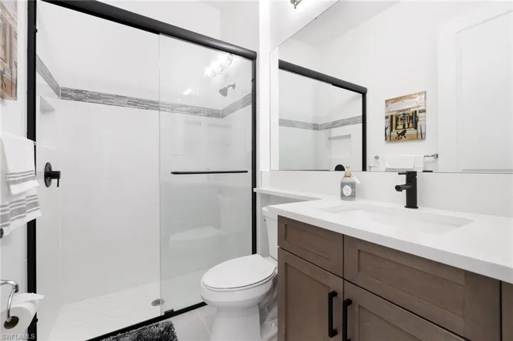 Bathroom featuring vanity, toilet, tile patterned floors, and walk in shower