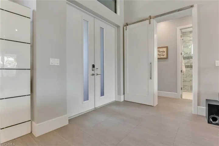 Foyer featuring french doors, a barn door, and light tile patterned flooring
