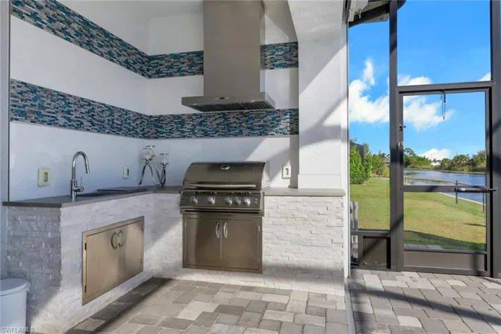 View of patio / terrace featuring a water view, grilling area, and a sunroom