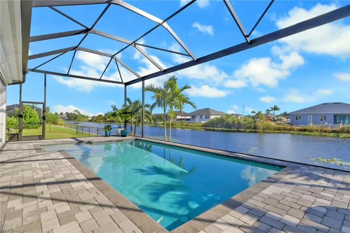Outdoor pool with a lanai, a water view, a sunroom, and a patio