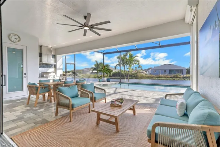 View of patio / terrace featuring outdoor lounge area, a sunroom, an outdoor pool, a ceiling fan, and glass enclosure
