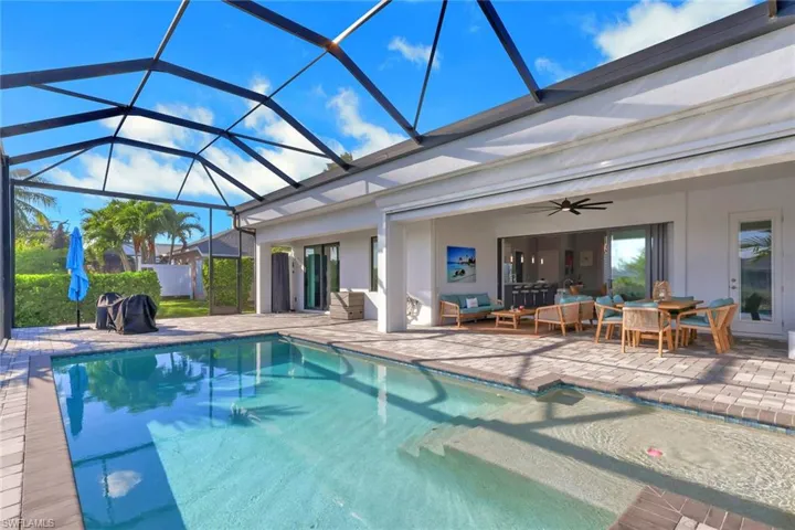 Outdoor pool with a patio area, an outdoor living space, glass enclosure, and ceiling fan
