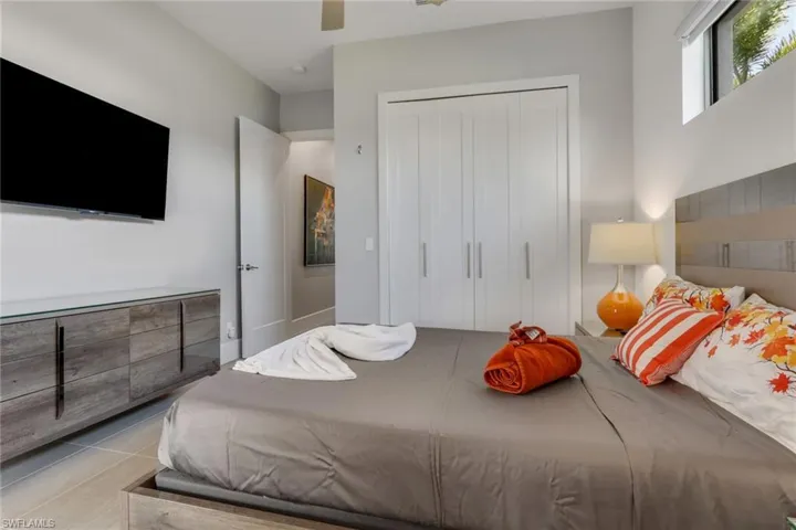 Bedroom with light tile patterned floors, a ceiling fan, and a closet