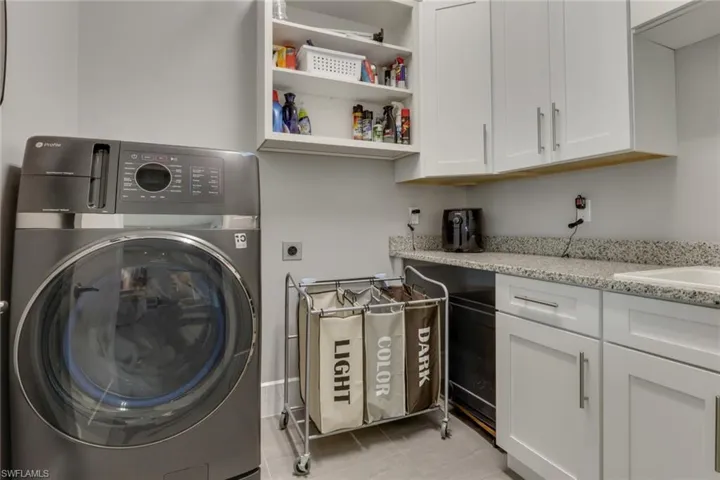 Laundry room featuring washer / dryer and light tile patterned flooring