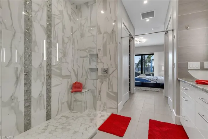 Bathroom with vanity, ensuite bath, a marble finish shower, and light tile patterned floors