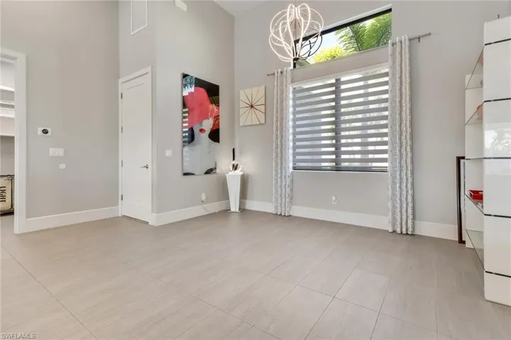 Empty room featuring a chandelier and light tile patterned flooring