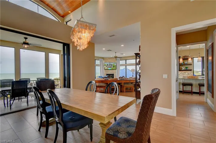Dining space featuring ceiling fan with notable chandelier and visible vents