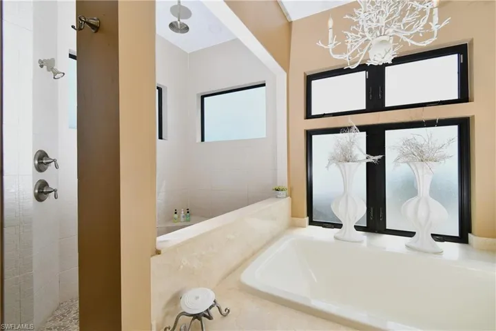 Bathroom featuring a notable chandelier, a water view, and a washtub