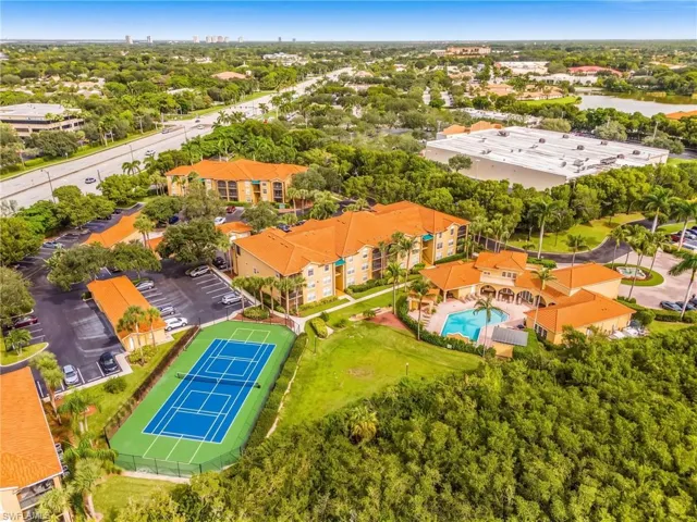 Mediterranean-style buildings with terra cotta tile roofs, a tennis court, a swimming pool, and a clubhouse