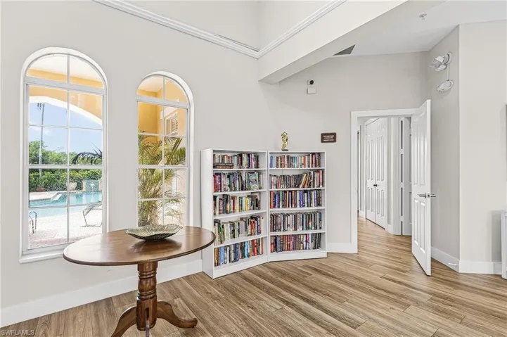 Arch-top windows, wood-finish flooring, high ceilings, recessed lighting, and white trim throughout