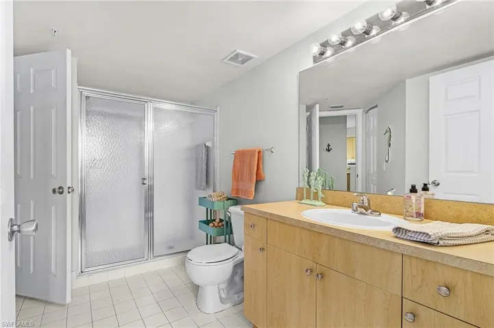 Full vanity with an integrated sink, wood-finish cabinetry, and a large mirror