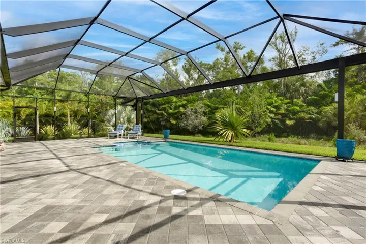 Swimming pool featuring a patio area and glass enclosure