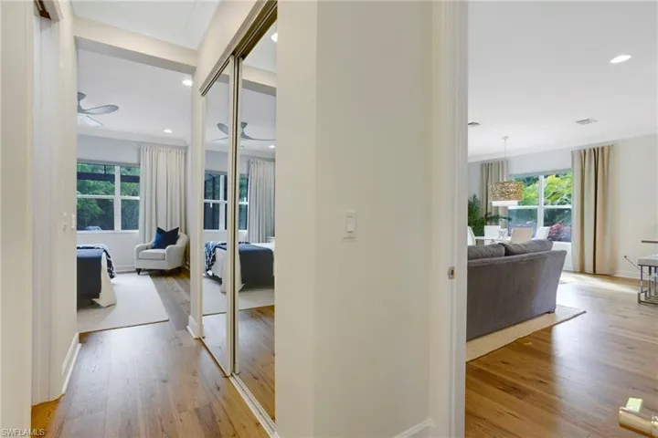Corridor with light wood-style flooring, ornamental molding, baseboards, and recessed lighting