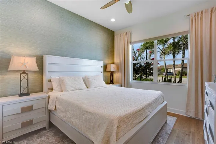 Bedroom featuring baseboards, wood finished floors, recessed lighting, a ceiling fan, and wallpapered walls